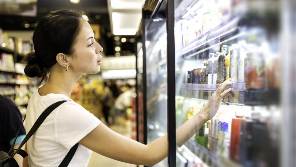 woman looking at product at grocery store